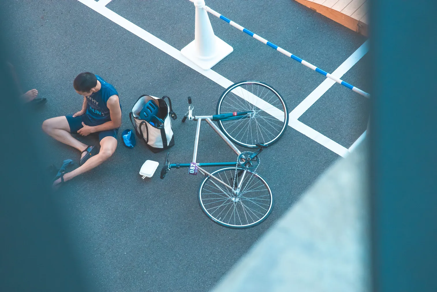 自転車のそばで座って休む人物を上から写した写真